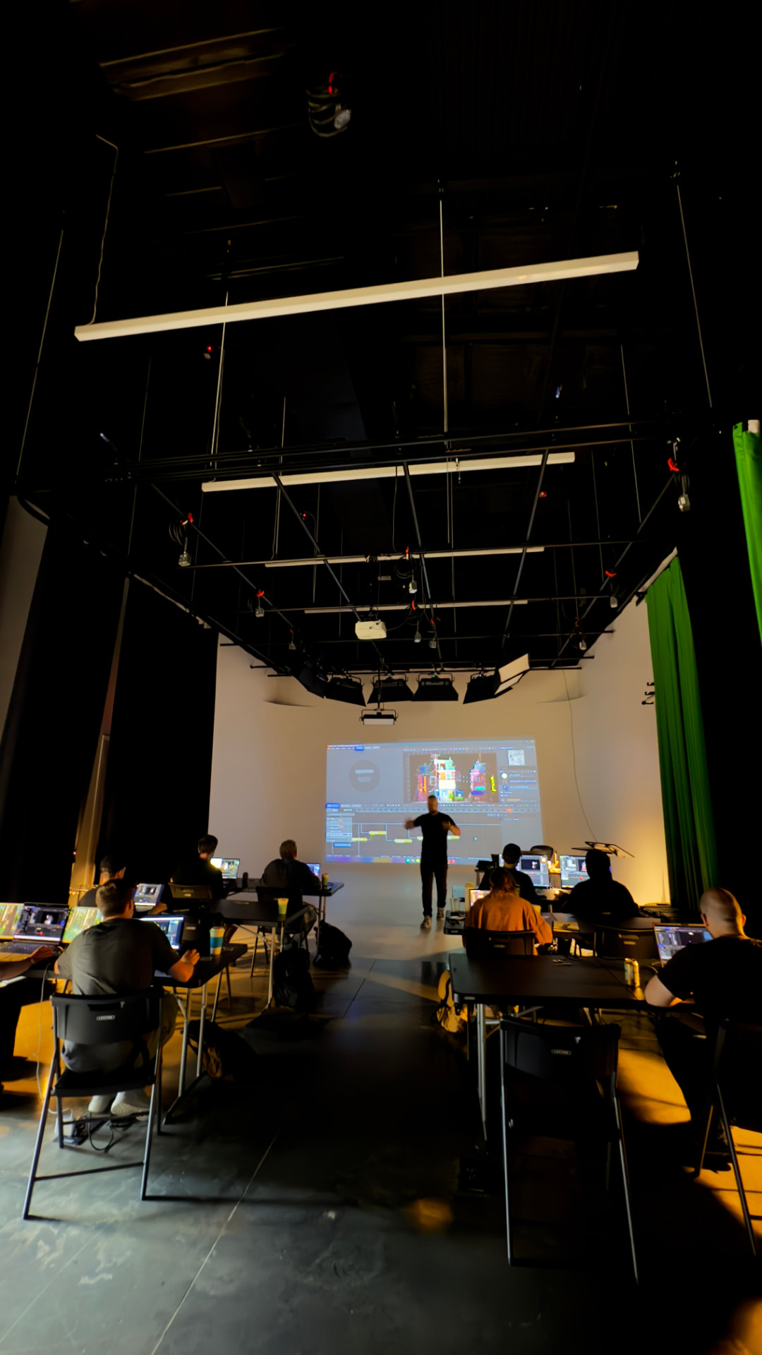 Workshop on The Stage with attendees at laptops and a projected screen